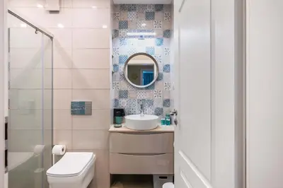 a bathroom with a sink and a toilet and a mirror at Sunny 1BR with Balcony in Sofia