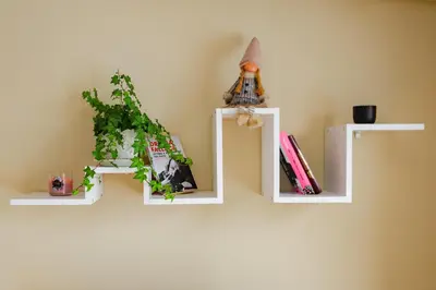 a wall with three white shelves with books at Sunny 1BR with Balcony in Sofia