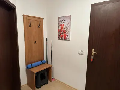 a room with a door and a chair and a refrigerator at Borealis Apartment in Bansko