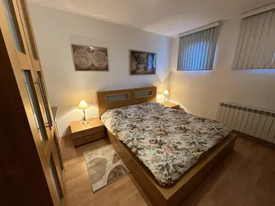 a bedroom with a bed and two lamps on tables at Borealis Apartment in Bansko