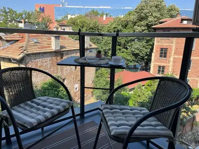 a balcony with two chairs and a table on a balcony at 5 minutes sity center plus parking in Plovdiv