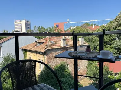 a table on a balcony with a view of a building at 5 minutes sity center plus parking in Plovdiv