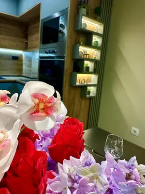 a table with red and white flowers on it at Regatta Park 1BR Exclusive Suite Parking Included in Plovdiv