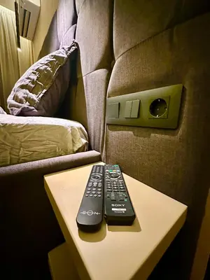 two remote controls sitting on a table next to a couch at Regatta Park 1BR Exclusive Suite Parking Included in Plovdiv