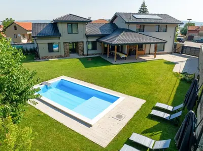 a backyard with a swimming pool and a house at Luxurious, modern house in the nature in Belchin in Belchin
