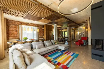 a living room with a white couch and a brick wall at Luxurious, modern house in the nature in Belchin in Belchin
