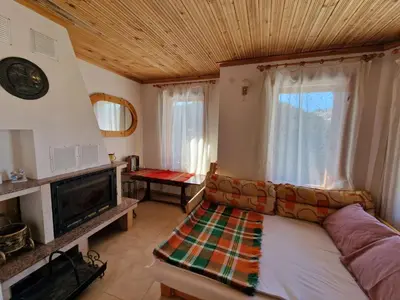 a living room with a couch and a fireplace at The House in Stoykite