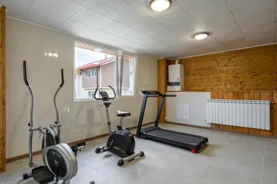 a gym with three exercise bikes in a room at Вила Звездопад in Manastir