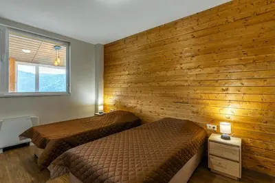 a bedroom with two beds and a wooden wall at Вила Звездопад in Manastir