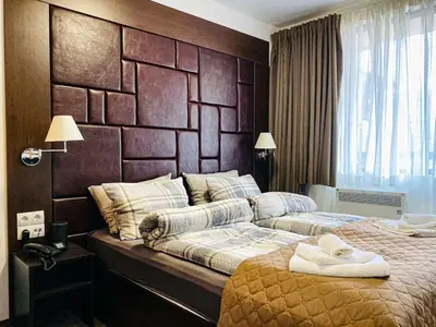 a bedroom with a large bed with a wooden headboard at Studio with pool, SPA near the Ski Lift in Bansko