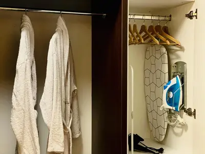 a closet with white towels and a surfboard in it at Studio with pool, SPA near the Ski Lift in Bansko