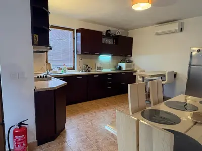 a kitchen with a sink and a table with chairs at Mountain Family Guest House Rayovo in Rayovo