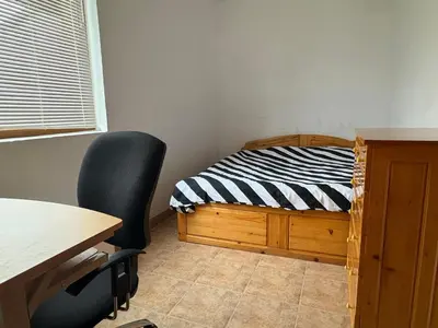 a room with a bed and a desk and a chair at Mountain Family Guest House Rayovo in Rayovo
