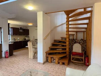 a living room with a spiral staircase and a kitchen at Mountain Family Guest House Rayovo in Rayovo