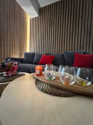 a living room with a couch and wine glasses on a table at 2-Bedroom Luxury Apartment in the center of Sofia in Sofia