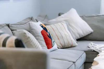 a couch with pillows on top of it at NDK - UrbanLux Medius 2BDR FREE Parking in Sofia