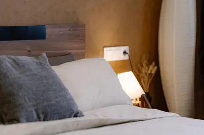 a bedroom with a bed with a pillow and a lamp at NDK - UrbanLux Medius 2BDR FREE Parking in Sofia