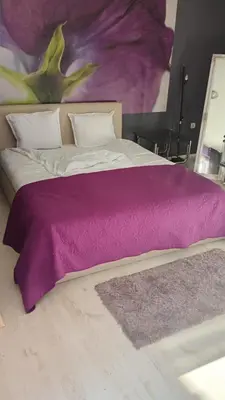 a bed with a purple blanket on top of it at Кичук Париж in Plovdiv