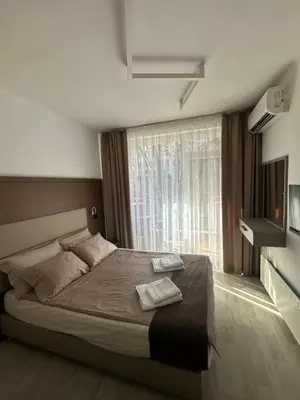 a bedroom with a large bed and a window at Velingrad Prime 2-Bedroom Apartment in Velingrad