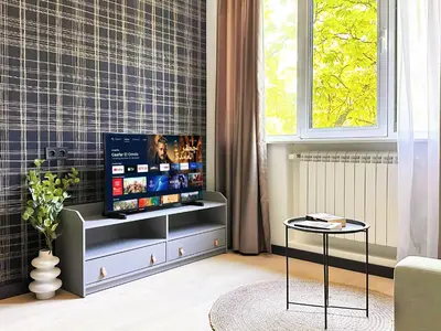 a living room with a tv and a table at Duplex Retreat 2 Studios Balconies, Wi-Fi in Sofia