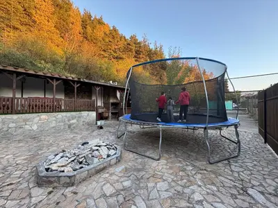 two people standing on a trampoline next to a fire at Delight House in Samokov