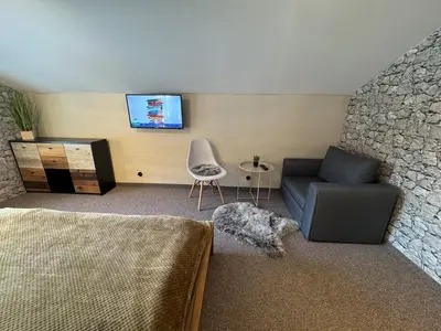 a living room with a couch and a tv on a wall at Delight House in Samokov