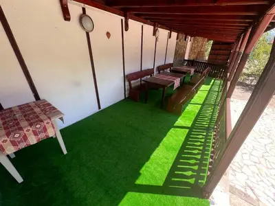 a room with benches and green grass on the floor at Delight House in Samokov