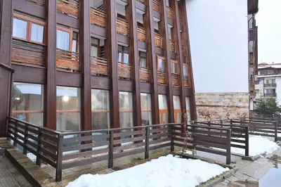a building with benches in the snow in front of it at The Mountain Hug Studio 1 by SI Stay in Bansko
