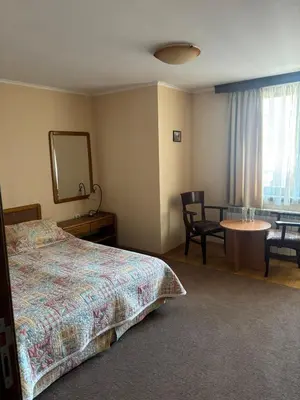a bedroom with a bed and a table and a mirror at Kalaydzhiev rooms in Bansko