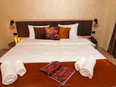 a bed with white towels and pillows on it at Hotel NIRÁ in Sofia