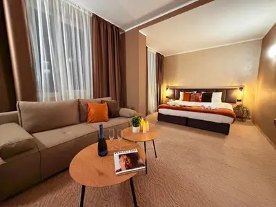 a living room with a couch and a bed at Hotel NIRÁ in Sofia