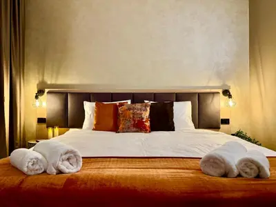 a bedroom with a large bed with towels on it at Hotel NIRÁ in Sofia