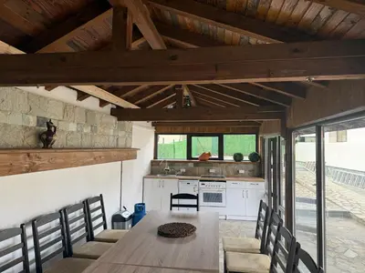 a kitchen and dining room with a table and chairs at Къща за гости Зорница in Ribarica