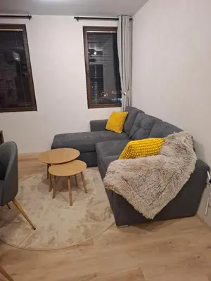a living room with a couch and a table at SkyCloud Bansko Cozy Modern 1 Min to Gondola in Bansko