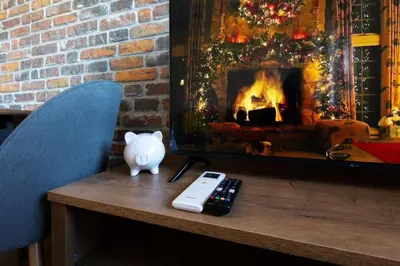 a table with a fireplace and a phone and a remote control at SkyCloud Bansko Cozy Modern 1 Min to Gondola in Bansko
