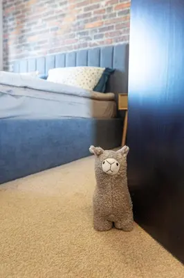 a stuffed cat sitting on the floor in a bedroom at SkyCloud Bansko Cozy Modern 1 Min to Gondola in Bansko