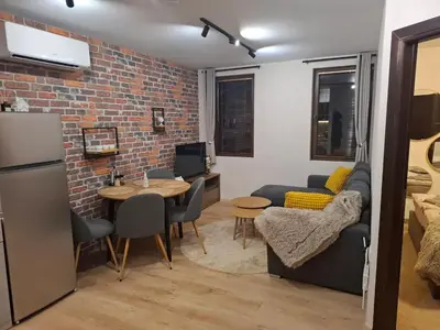 a kitchen and living room with a brick wall at SkyCloud Bansko Cozy Modern 1 Min to Gondola in Bansko