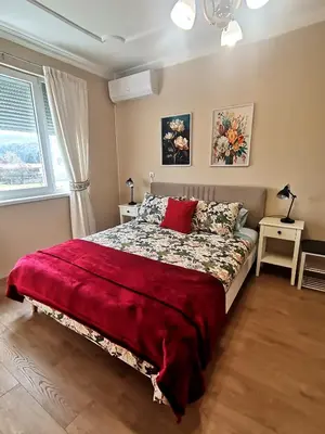 a bedroom with a bed with a red blanket on it at Апартамент Релакс in Velingrad