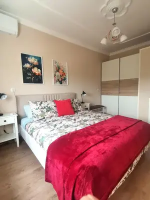a bedroom with a large bed with a red blanket at Апартамент Релакс in Velingrad