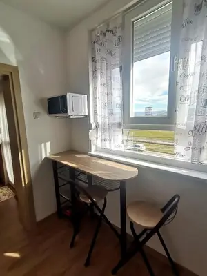 a small table and two chairs in a room with a window at Апартамент Релакс in Velingrad