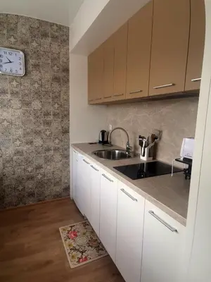 a kitchen with white cabinets and a sink at Апартамент Релакс in Velingrad
