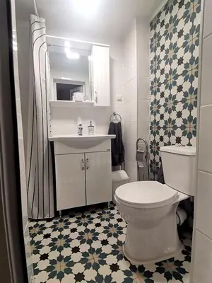 a bathroom with a white toilet and a sink at Апартамент Релакс in Velingrad