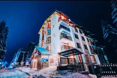 a large white building with snow on the ground at Пампорово Mountain Lodge апартамент 46 in Pamporovo