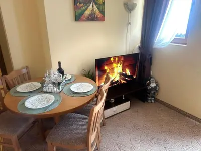 a dining room with a table with a fireplace at Пампорово Mountain Lodge апартамент 46 in Pamporovo