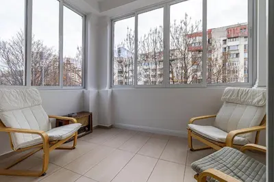 a living room with two chairs and windows at Grand Stamboliyski Residence in Sofia