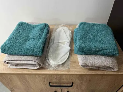 two towels and a pair of shoes on a wooden shelf at Бунгала ЛАГО