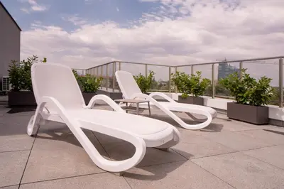 three white chairs sitting on top of a roof at Blue Sky Penthouse with Parking Spot and Panorama Views in Sofia
