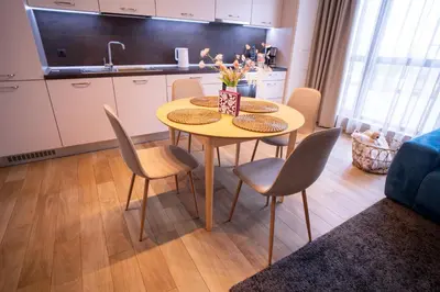 a kitchen with a table and chairs in a room at Blue Sky Penthouse with Parking Spot and Panorama Views in Sofia