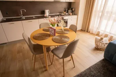 a dining room table with chairs and a kitchen at Blue Sky Penthouse with Parking Spot and Panorama Views in Sofia
