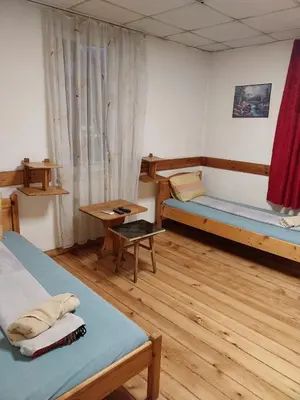a room with two beds and a table at Скай Румс -3 in Sofia